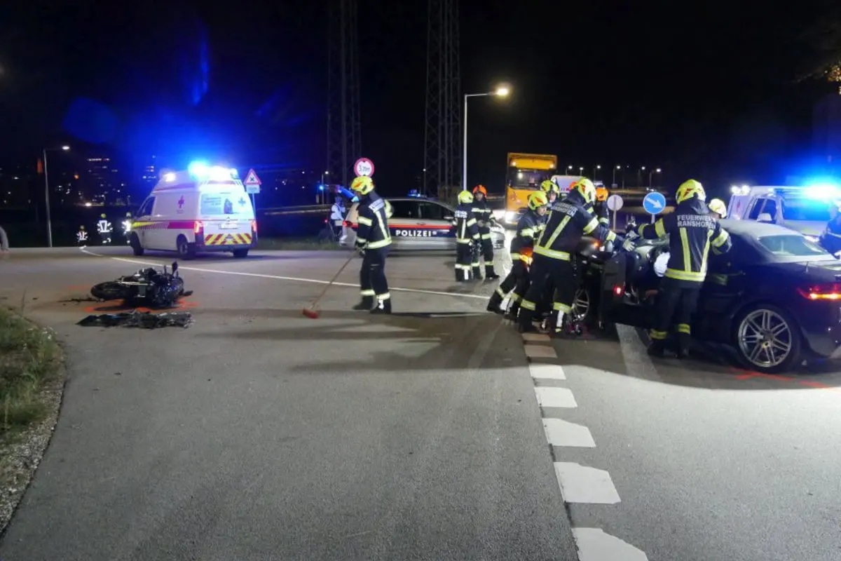 Bei Nacht arbeiten Feuerwehrleute und Polizisten an einem Unfallort, ein Motorrad liegt auf der Straße.