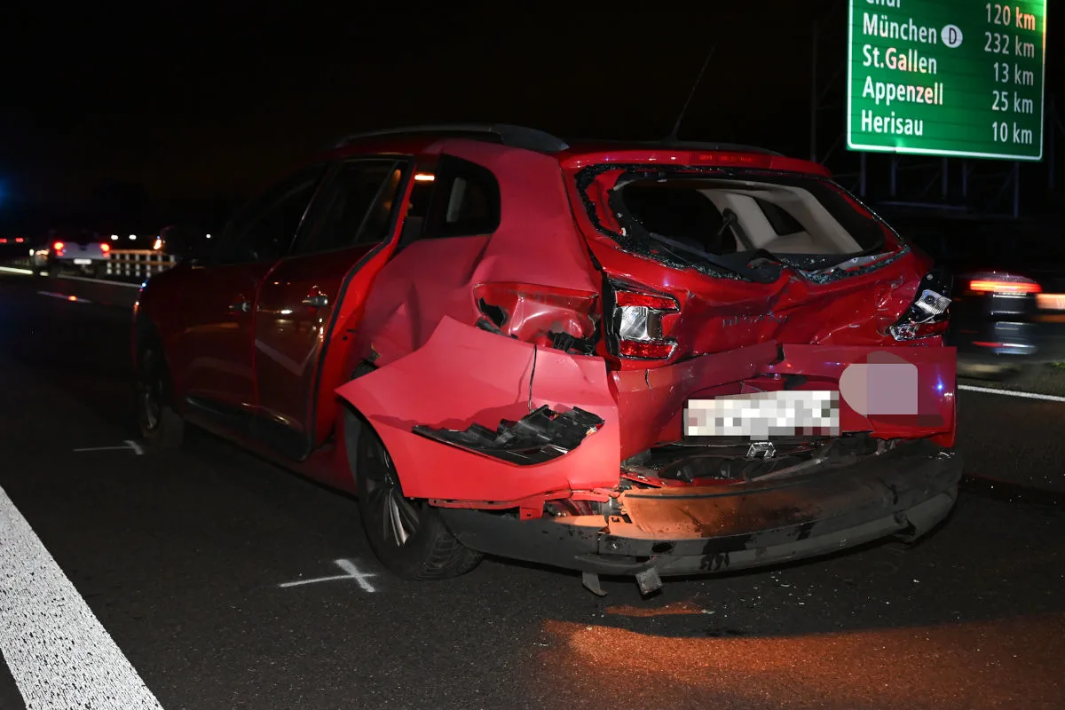 Ein rotes Auto mit erheblichem Heckschaden steht auf einer autobahn. Zeichen auf der Fahrbahn deuten auf Unfalluntersuchung hin.