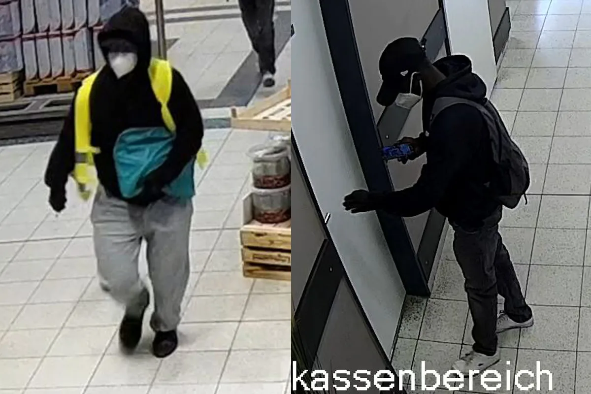 Zwei maskierte Personen in einem Supermarkt. Eine trägt einen gelben Rucksack und geht durch einen Gang, die andere steht nah an der Kasse.