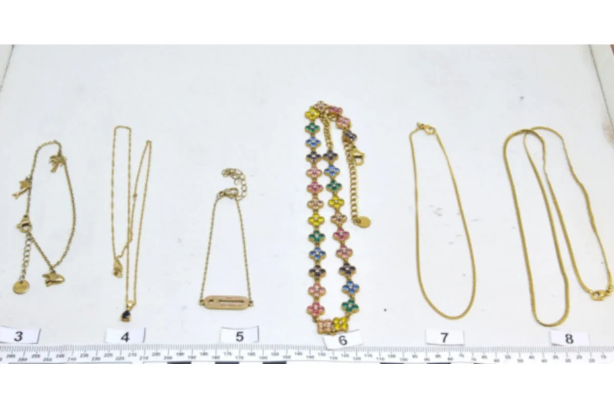 Auf einem weißen Untergrund sind mehrere Schmuckstücke, darunter Ketten und Armbänder, nummeriert und nebeneinander dargestellt.