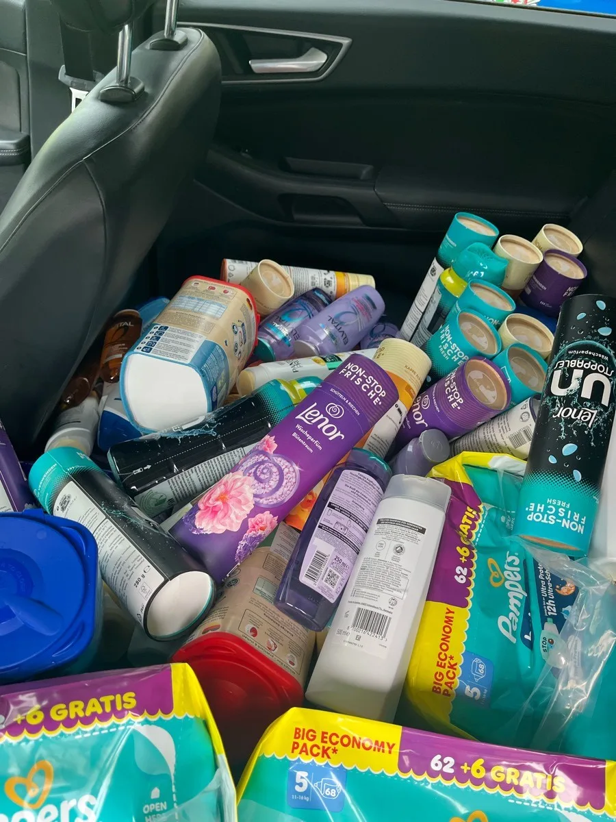 Der Rücksitz eines Autos ist komplett mit verschiedenen Haushaltsprodukten wie Shampoos und Windeln gefüllt.