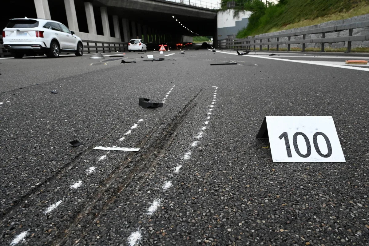 Auf einer Autobahn sind Bremsspuren und Trümmerteile sichtbar. Eine Beweismarkierung mit der Nummer 100 ist aufgestellt.