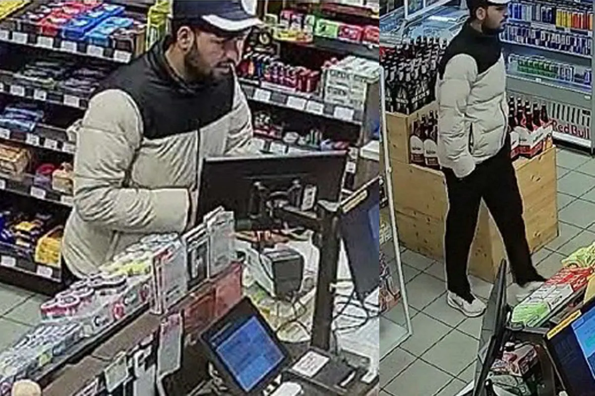 Ein Mann mit hellem Mantel wird an der Kasse eines Supermarkts von Überwachungskameras gefilmt, neben Regalen mit Produkten.