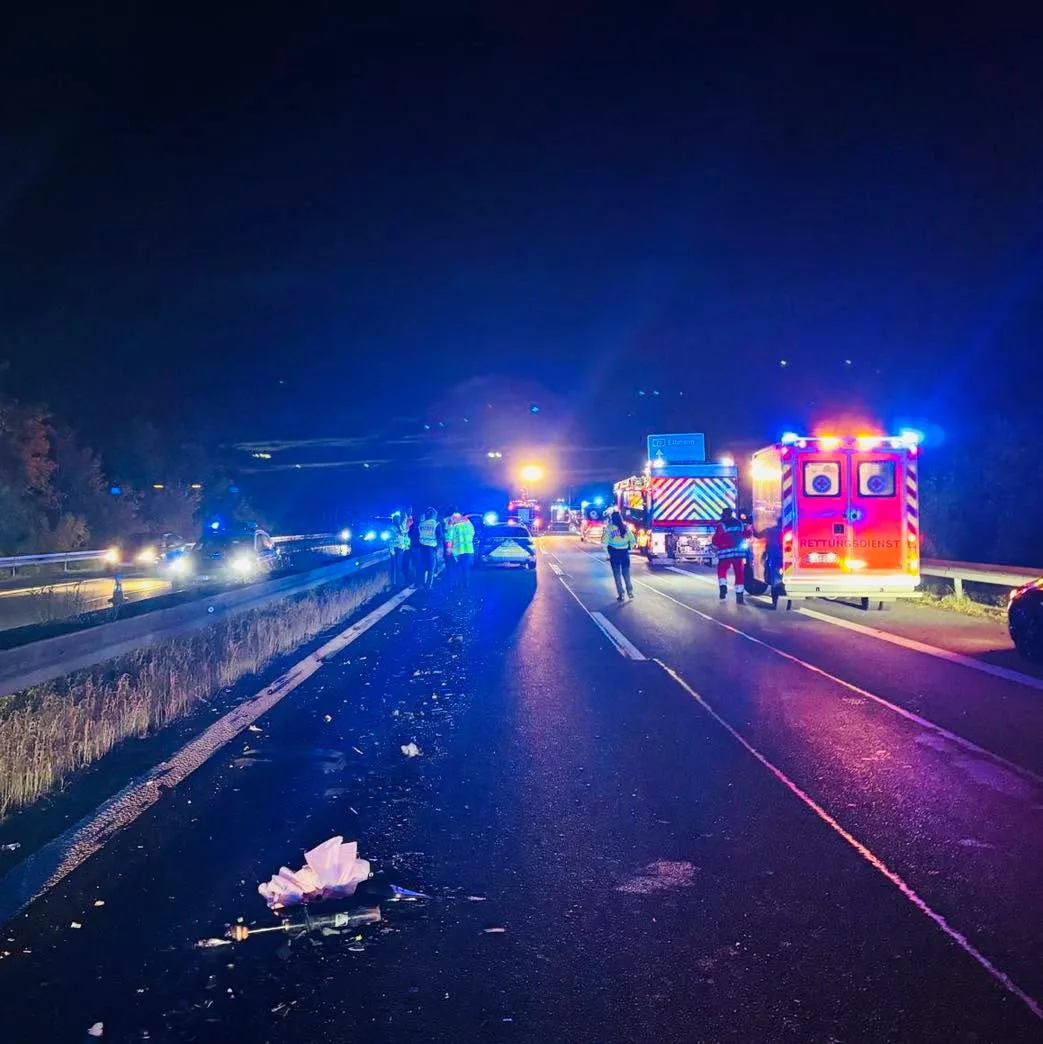 Mehrere Einsatzfahrzeuge mit Blaulicht stehen auf einer nächtlichen Autobahn. Einsatzkräfte sind auf der Fahrbahn aktiv.