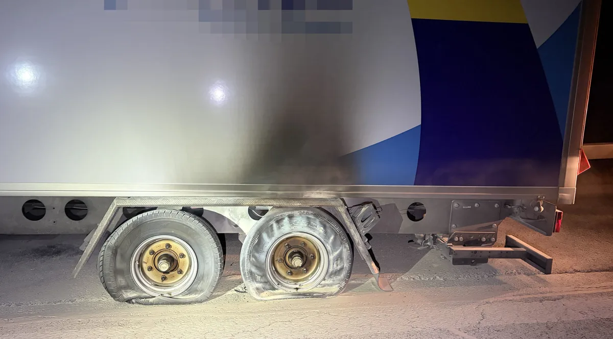 Das Bild zeigt zwei beschädigte Reifen eines Anhängers. Die Reifen sind abgeflacht und weisen Brandschäden auf.