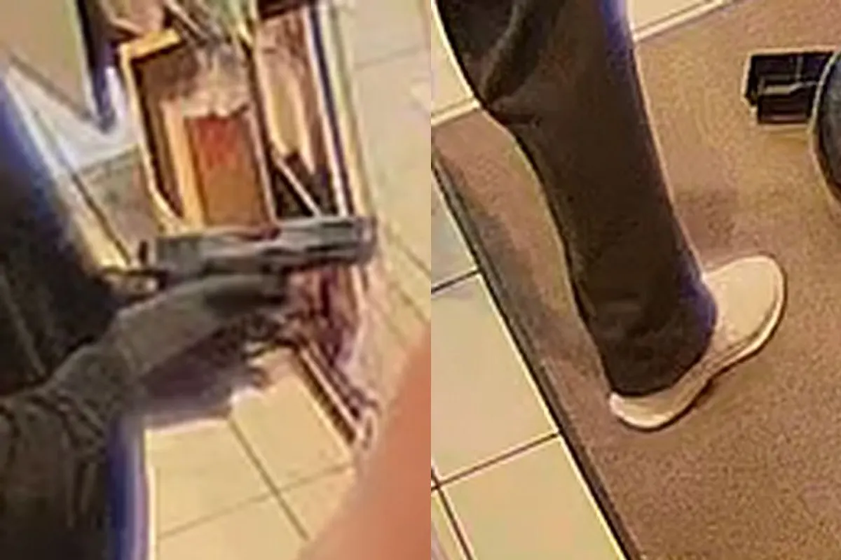 Eine Person hält eine Schusswaffe in einem Innenbereich. Der Boden ist gefliest, und es sind Beine einer anderen Person zu sehen.