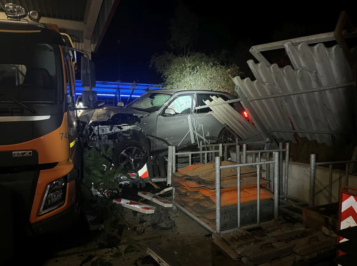 Ein SUV ist bei Nacht in die Ecke eines Gebäudes gefahren, Teile der Fassade sind eingestürzt. Ein Lastwagen steht daneben.