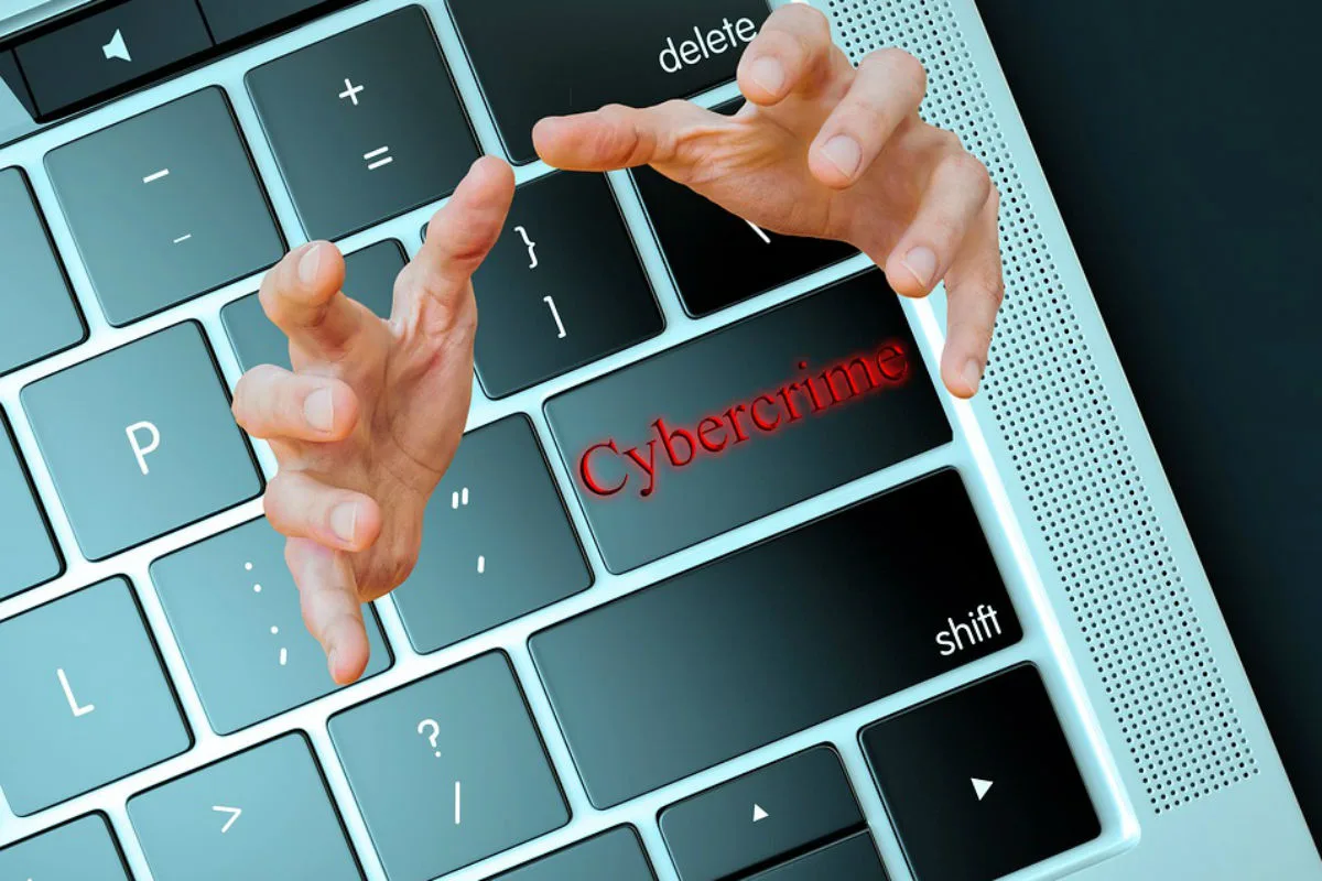Das Bild zeigt eine Computertastatur mit hervorgehobenen Tasten. Zwei Hände scheinen über der Tastatur zu schweben, bei der das Wort 'Cybercrime' auf einer Taste steht.