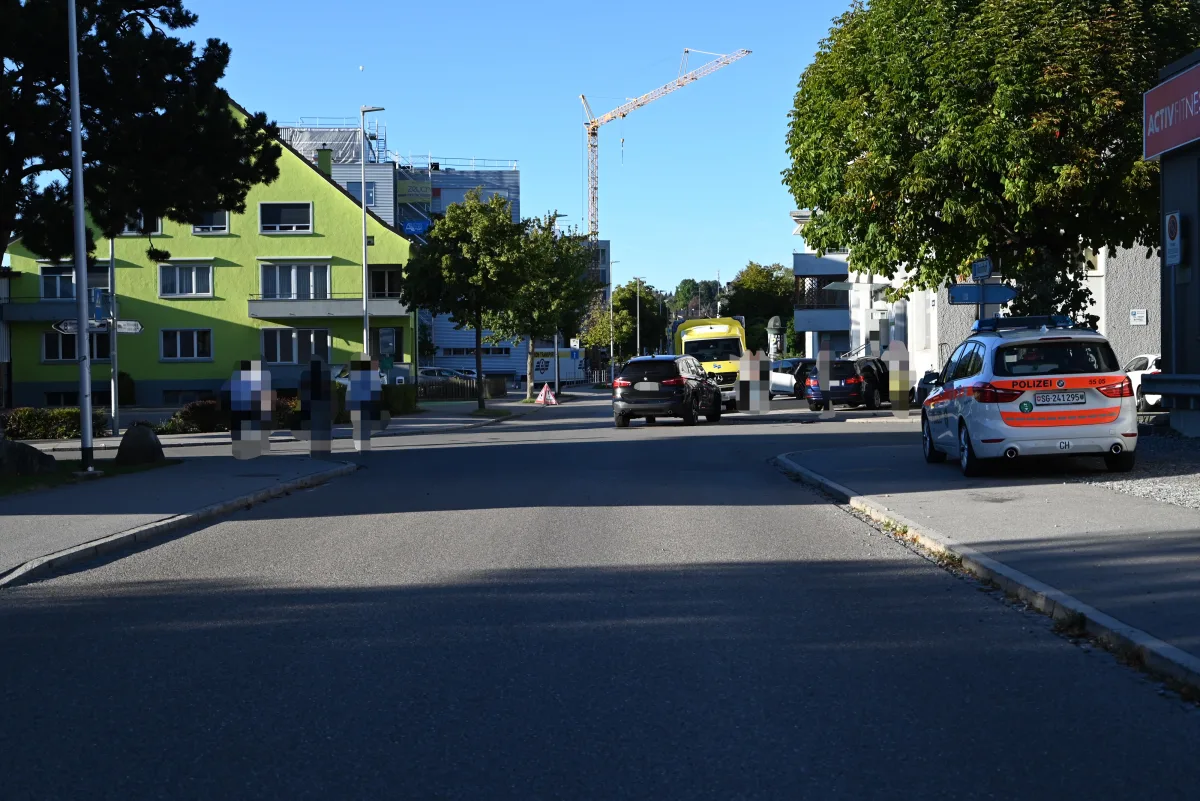 Ein Polizeifahrzeug steht am rechten Straßenrand einer städtischen Straße. Im Hintergrund sind mehrere Autos und Gebäude sichtbar.