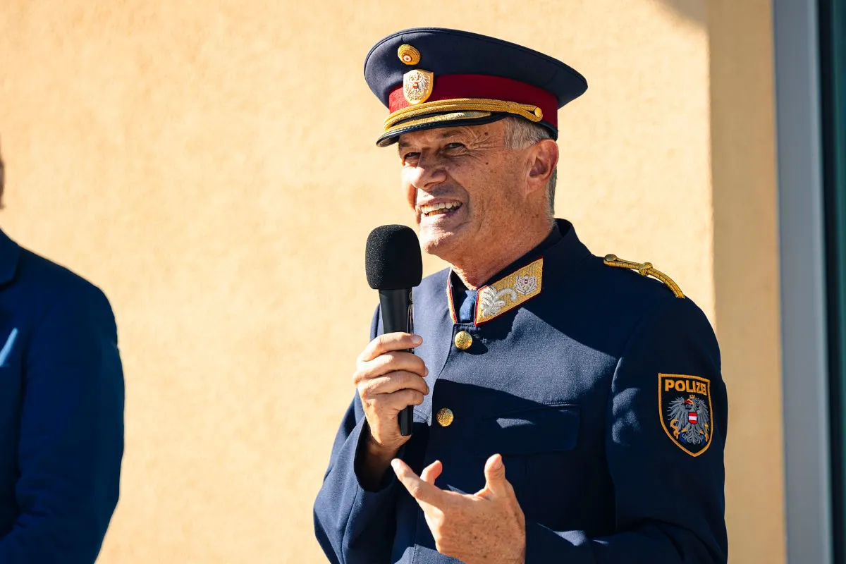 Ein Polizist in österreichischer Uniform redet in ein Mikrofon. Im Hintergrund ist eine helle Wand zu sehen.
