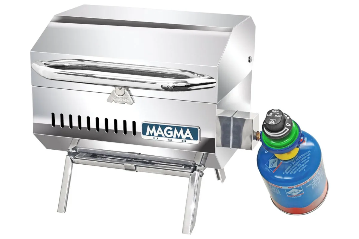 Der silberne Gasgrill mit der Aufschrift 'MAGMA' ist kompakt und hat einen blauen Gasbehälter angeschlossen.