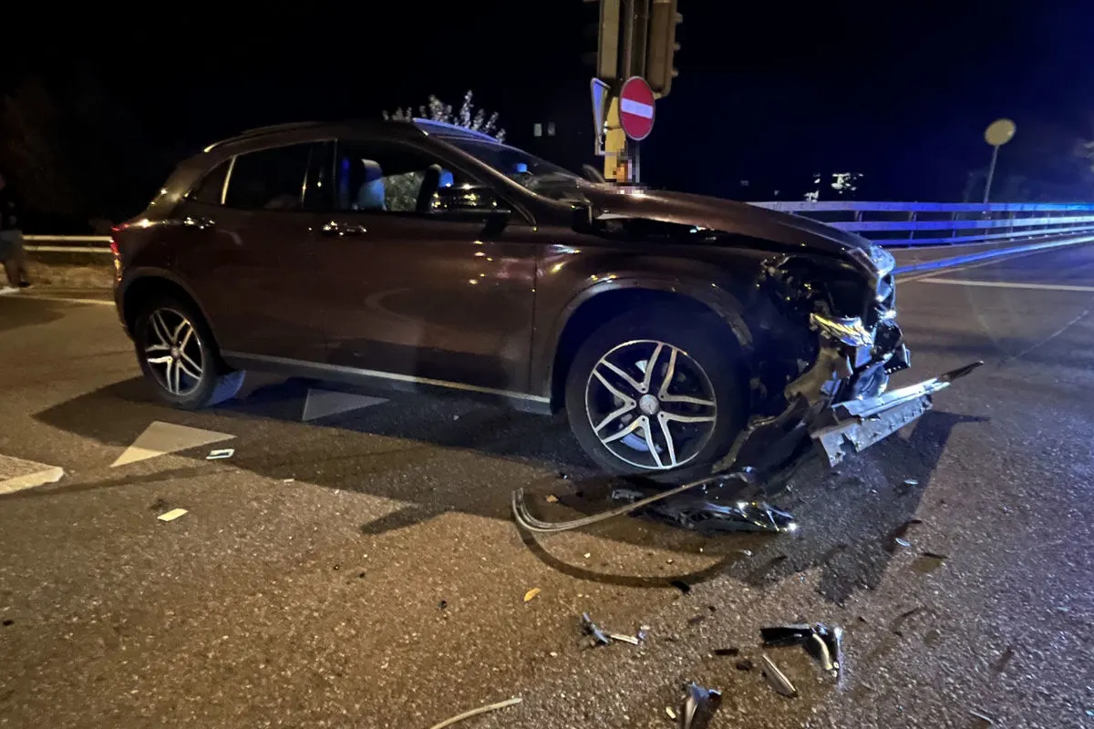 Ein dunkler Pkw mit erheblichen Frontschäden steht an einer nächtlichen Kreuzung. Trümmerteile liegen auf der Straße.