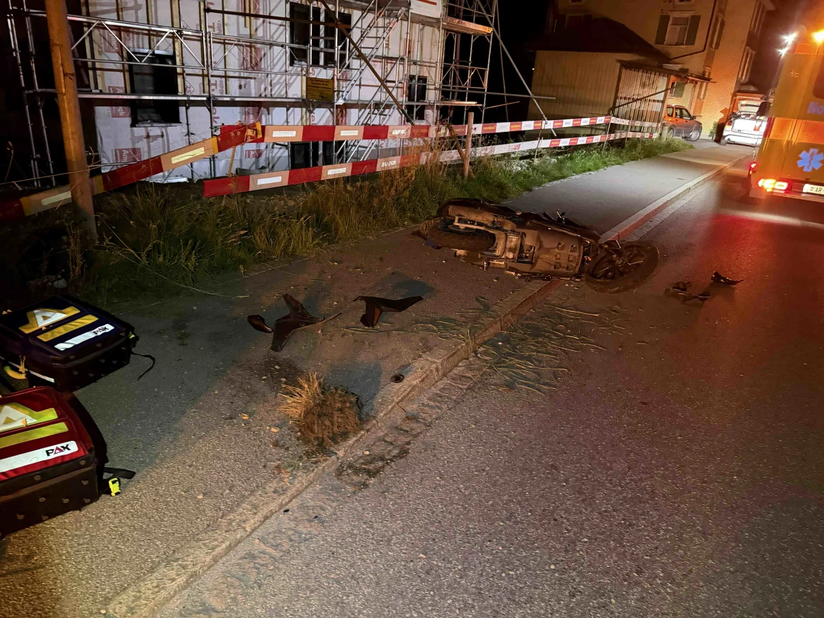 Ein umgestürztes Motorrad liegt auf der Straße, umgeben von Trümmerteilen. Im Hintergrund ist eine Baustelle sichtbar.