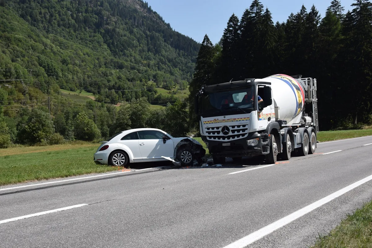 Ein weißer VW steht nach einem Zusammenstoß auf einer Landstraße, die Front ist gegen einen Betonmischer geprallt.