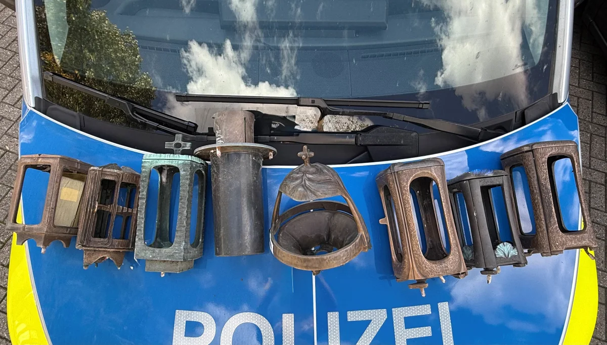 Mehrere gestohlene Metallornamente sind auf der blau-gelben Motorhaube eines Polizeifahrzeugs ausgebreitet.