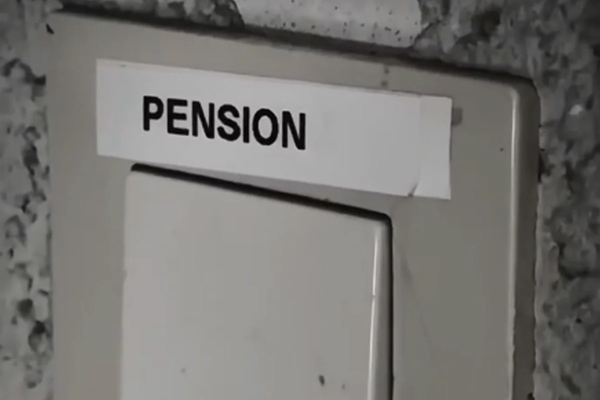 Ein Schild mit der Aufschrift 'Pension' ist über einem Wandschalter angebracht. Im Hintergrund ist eine strukturierte Wand erkennbar.