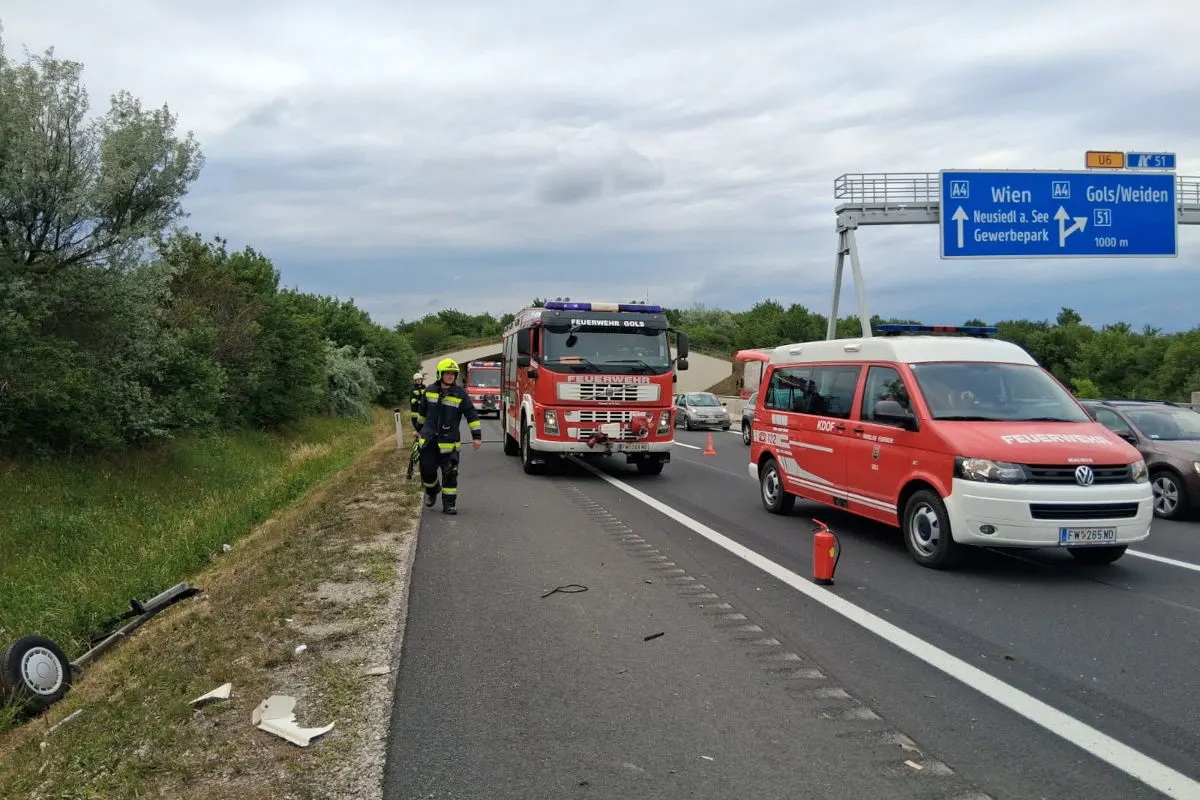 Zwei Feuerwehrfahrzeuge und Einsatzkräfte sind auf einer Autobahn nahe einer Ausfahrt im Einsatz. Ein Feuerlöscher steht auf der Straße.
