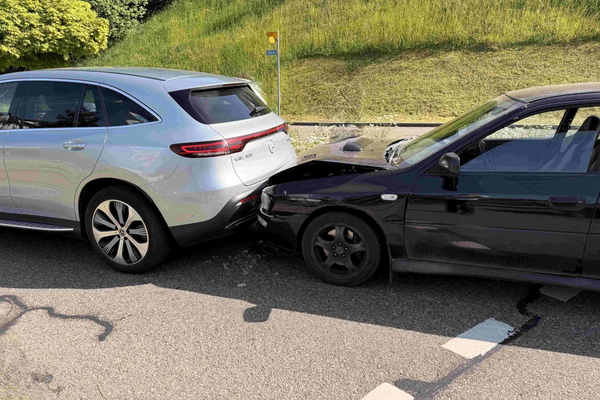 Ein silberner Mercedes SUV und ein schwarzes Auto sind auf einer Landstraße zusammengestoßen. Der Mercedes hat hinten Schäden.