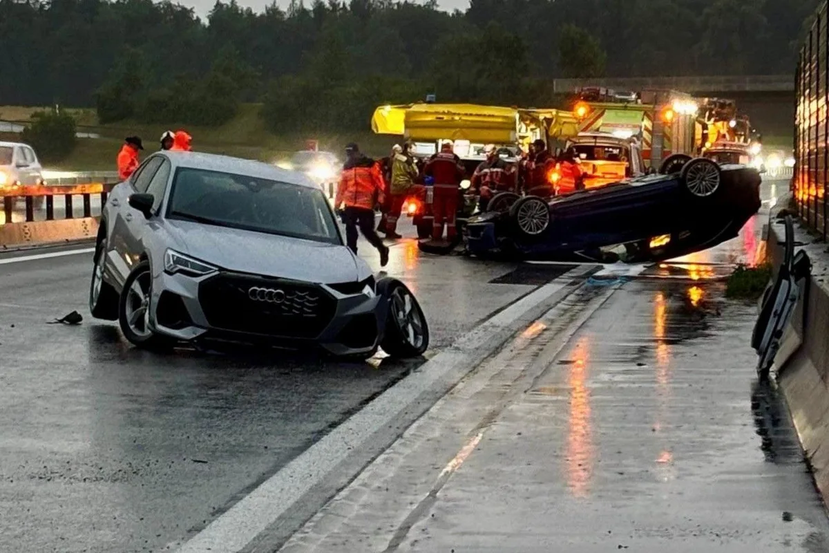 Auf der Autobahn stehen zwei verunfallte Fahrzeuge, ein Audi und ein umgekippter SUV. Rettungskräfte sind im Einsatz.