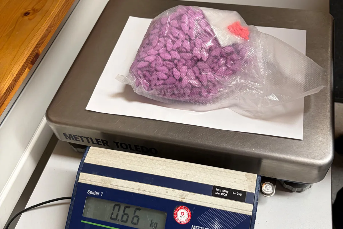 Ein durchsichtiger Beutel mit lilafarbenen Tabletten liegt auf einer Mettler Toledo Waage. Die Anzeige zeigt 0,66 kg.