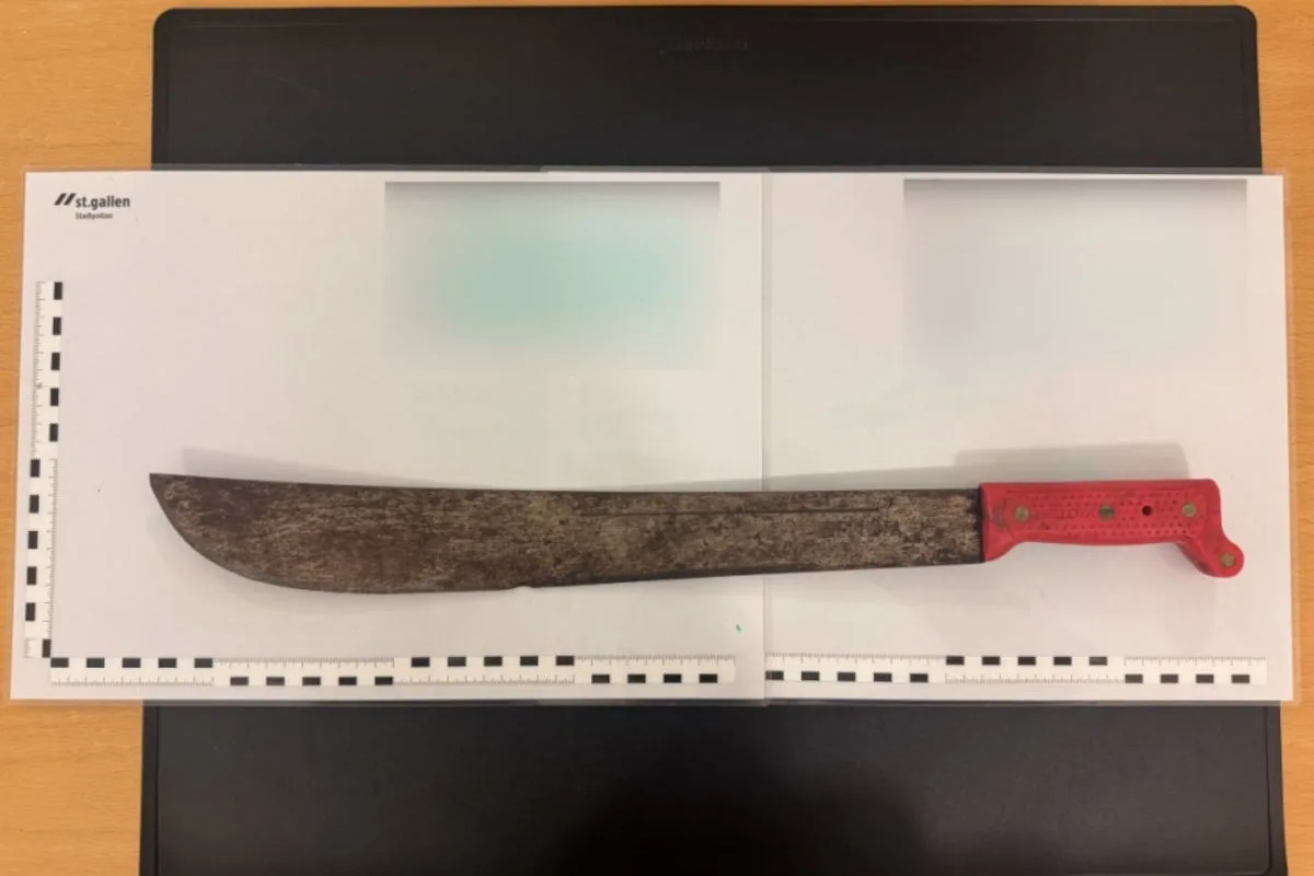 Eine verrostete Machete mit einem roten Griff liegt auf einem Polizeiunterlagenbogen der Stadtpolizei St. Gallen.