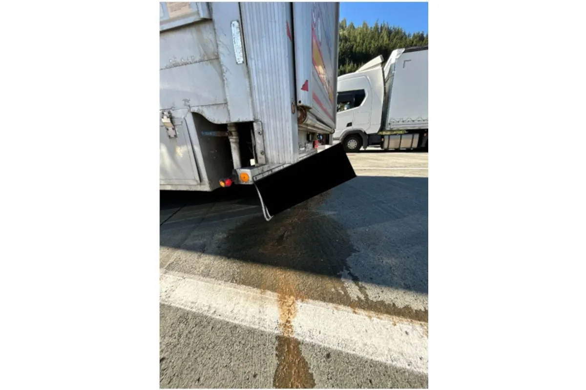 Die Rückseite eines Lkw-Anhängers zeigt austretende braune Flüssigkeit, die sich auf dem Boden verteilt.