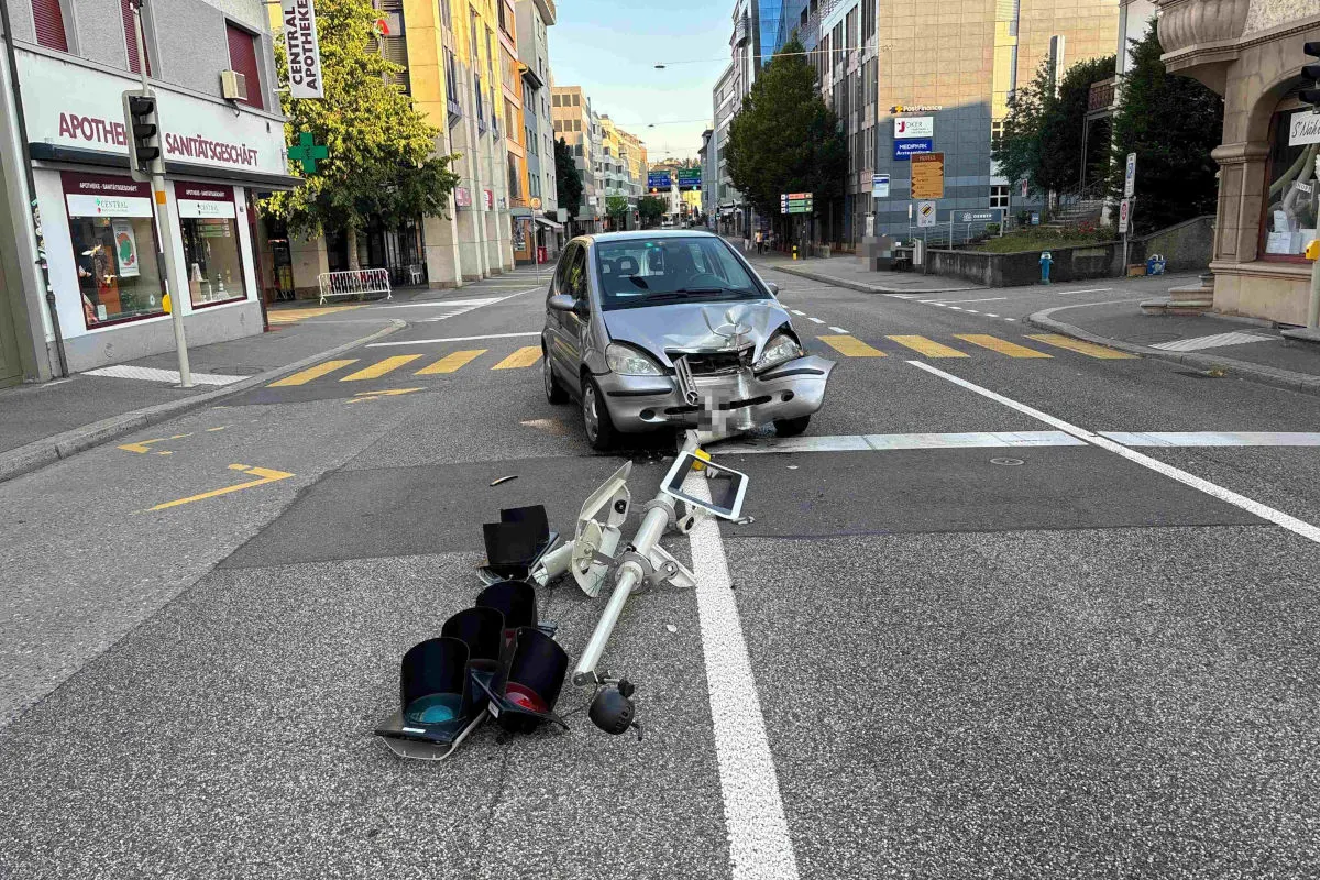 Ein silbernes Auto steht stark beschädigt auf einer Kreuzung. Eine Ampel liegt umgefahren auf dem Boden.