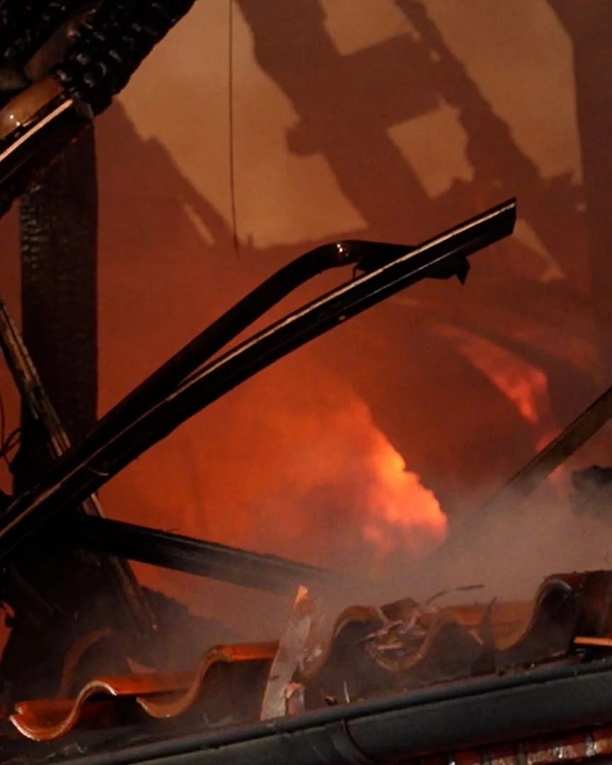 Ein Fahrzeug steht in Flammen, mit sichtbaren Flammen und Rauch, umgeben von dunkler Umgebung.