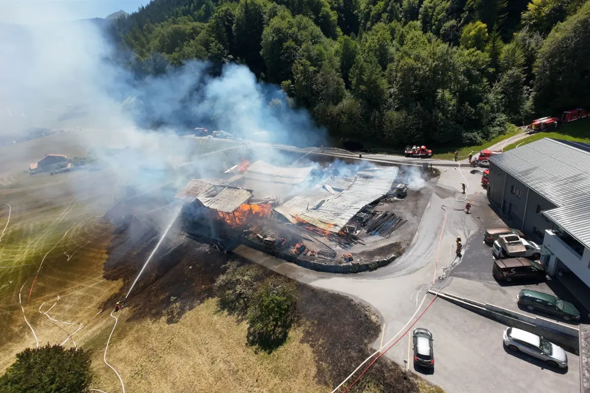 Ein großes Feuer hat eine Scheune in einer ländlichen Gegend erfasst, während Feuerwehrleute versuchen, die Flammen zu löschen.