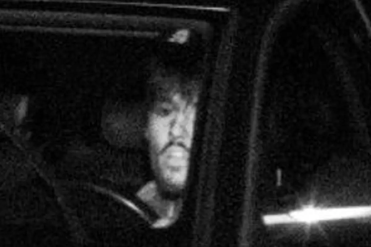 Eine Person sitzt in einem Fahrzeug, aufgenommen bei Nacht. Die Schwarz-Weiß-Aufnahme zeigt einen Mann mit Bart am Steuer.
