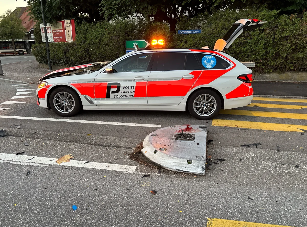 Ein Polizeiauto der Kantonspolizei Solothurn steht neben einem beschädigten Verkehrsschild auf einer Straße. Teile des Schilds und mehrere Trümmer liegen auf der Fahrbahn.