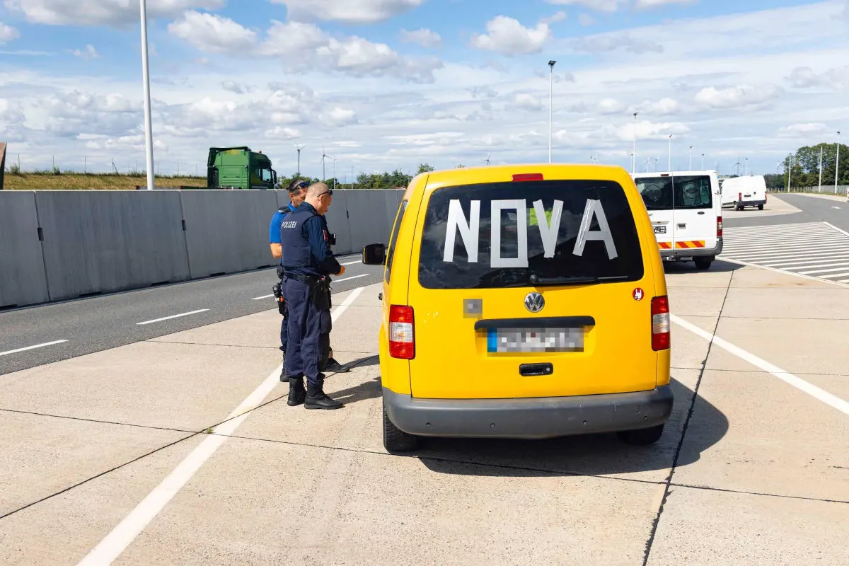 Zwei Polizisten stehen neben einem gelben VW-Transporter auf einem Autobahnparkplatz. Der Transporter hat den Schriftzug 'NOVA' auf der Heckscheibe.