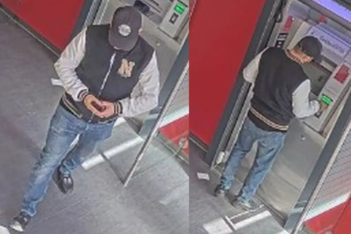 Ein Mann mit Baseballkappe und Jacke steht an einem Geldautomaten und nutzt das Gerät.