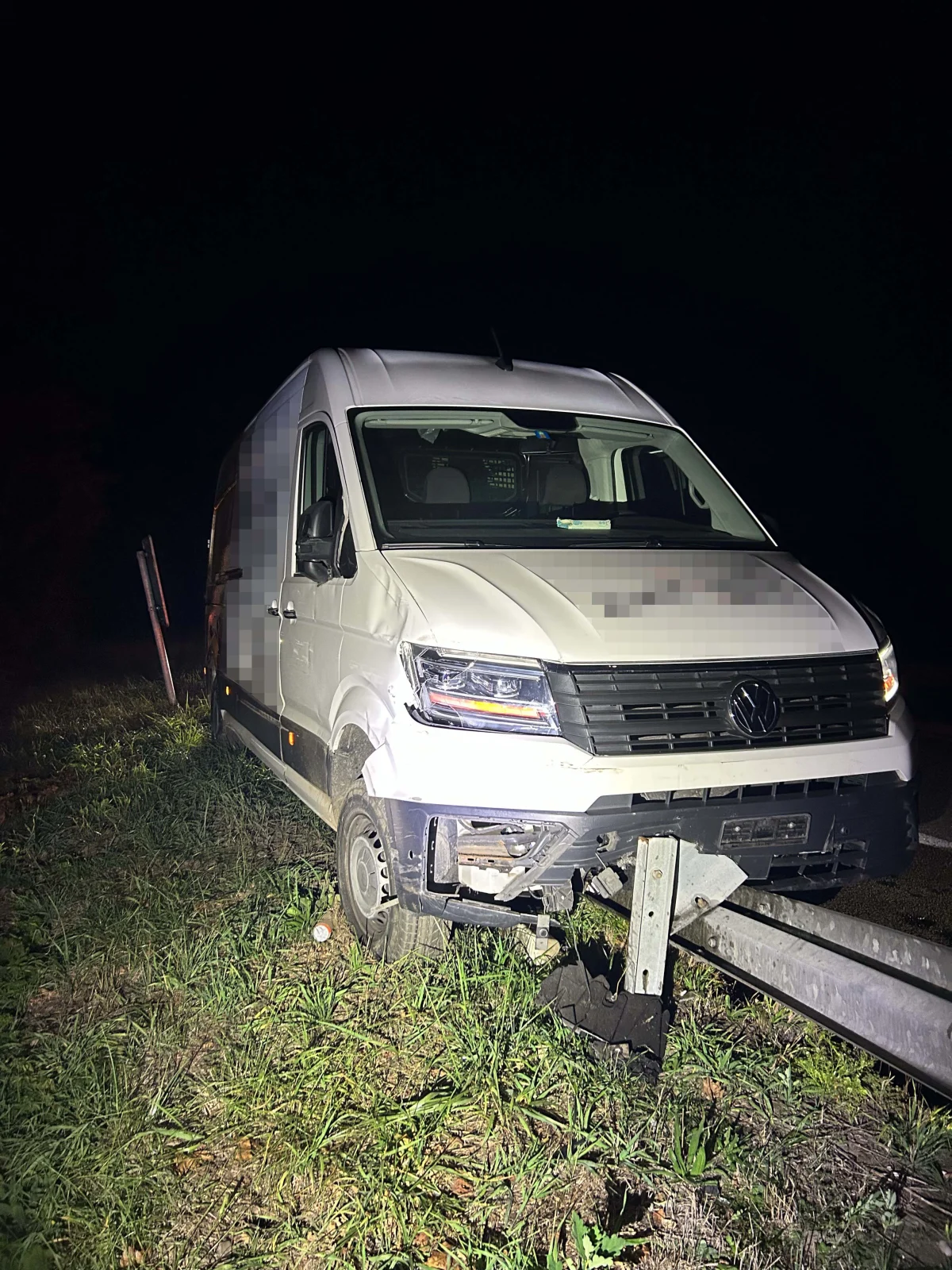 Ein weißer Transporter der Marke VW ist frontal gegen eine Leitplanke gefahren. Der Unfall ereignete sich nachts.