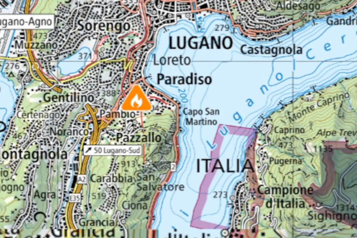 Ein Kartenausschnitt von Lugano zeigt ein Feuersymbol südlich der Stadt. Dies signalisiert einen potenziellen Brandort.