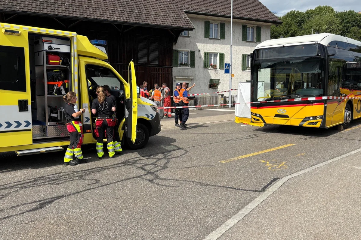 Ein gelber Rettungswagen steht offen, während Rettungskräfte vor einem abgesperrten Bereich arbeiten. Ein Linienbus ist ebenfalls sichtbar.
