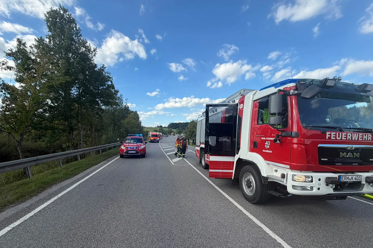 Mehrere Feuerwehrfahrzeuge stehen auf einer abgelegenen Landstraße. Feuerwehrleute sind vor Ort aktiv.