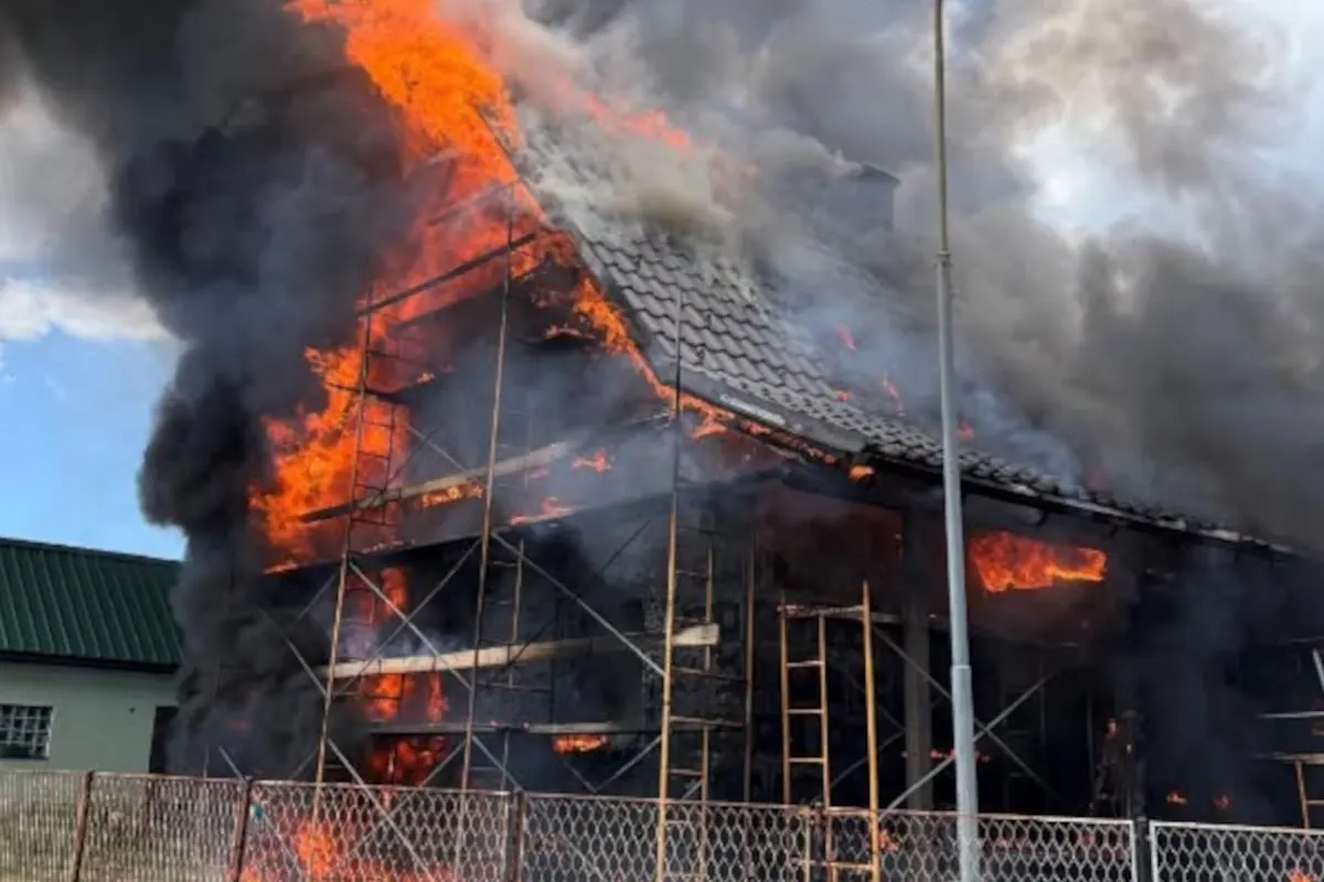 Ein großes Gebäude steht in Flammen, schwarzer Rauch steigt in den Himmel. Ein Gerüst ist zu sehen.