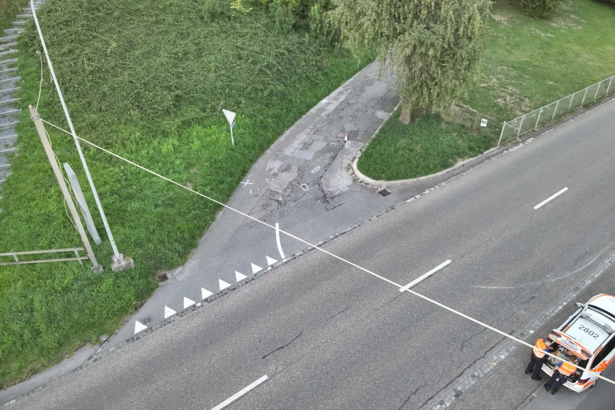 Ein Polizeiauto steht abgesperrt auf einer Landstraße. Das Band verläuft quer über die Fahrbahn.