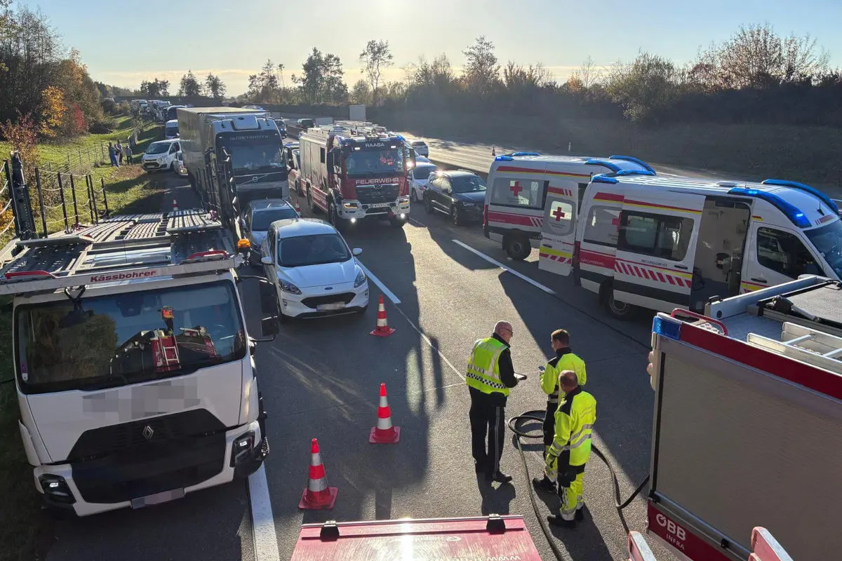 Verschiedene Rettungsfahrzeuge, darunter Krankenwagen und Feuerwehr, stehen auf der Autobahn. Einsatzkräfte sind vor Ort.