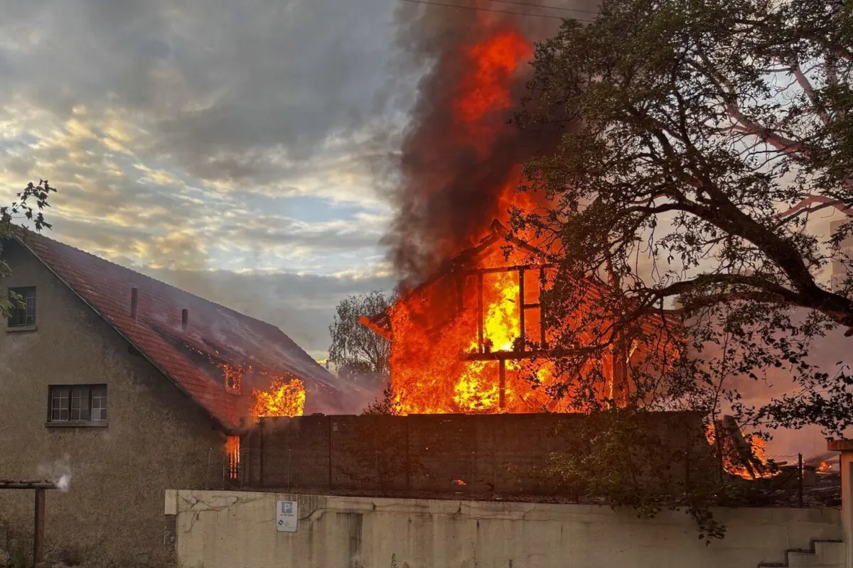 Ein Wohnhaus steht bei Tageslicht in Flammen, mit dichten Rauchwolken, die in den Himmel emporsteigen.