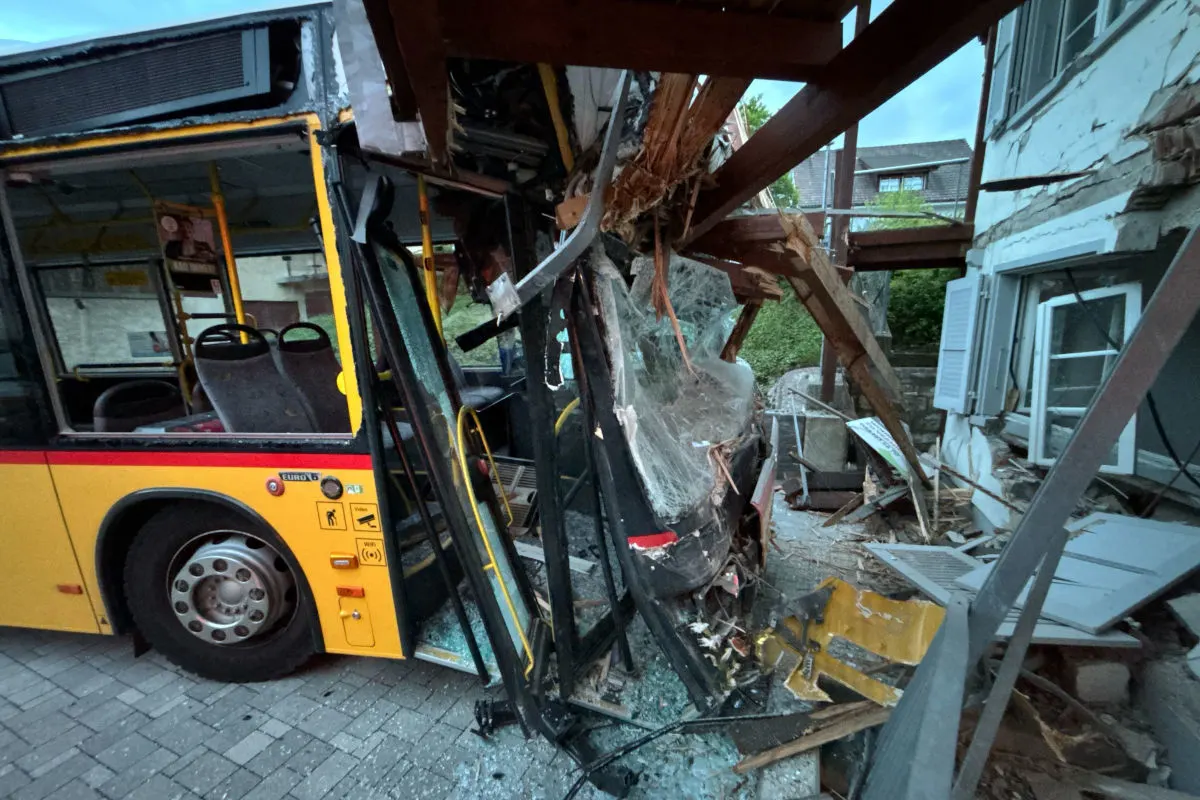 Ein gelber Bus ist frontal in ein Gebäude gekracht. Die Struktur des Gebäudes ist beschädigt, und Trümmer liegen verstreut auf dem Boden.