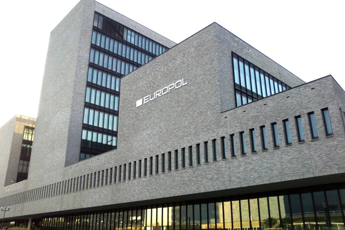 Das Bild zeigt das moderne, mehrstöckige Gebäude von Europol in Den Haag mit dem Europol-Schriftzug an der Fassade.