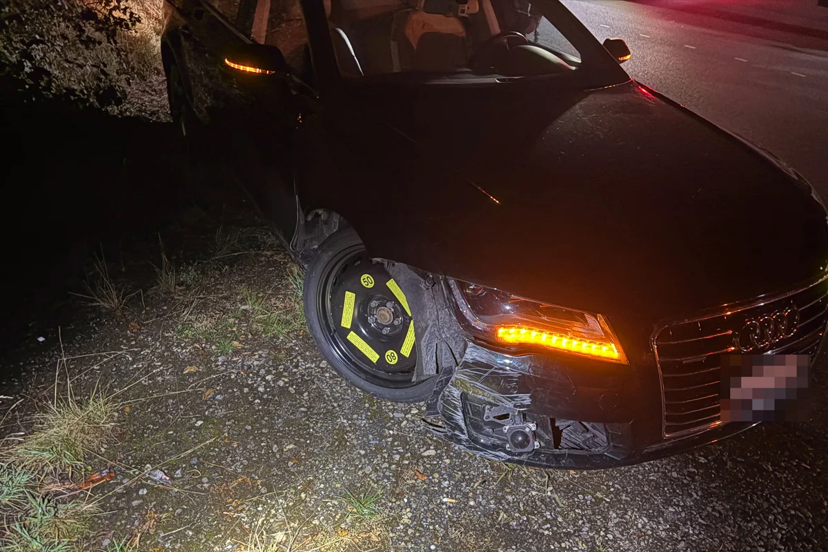 Ein schwarzer Audi steht bei Nacht am Straßenrand. Die Frontpartie ist beschädigt und das Fahrzeug hat ein Notrad.