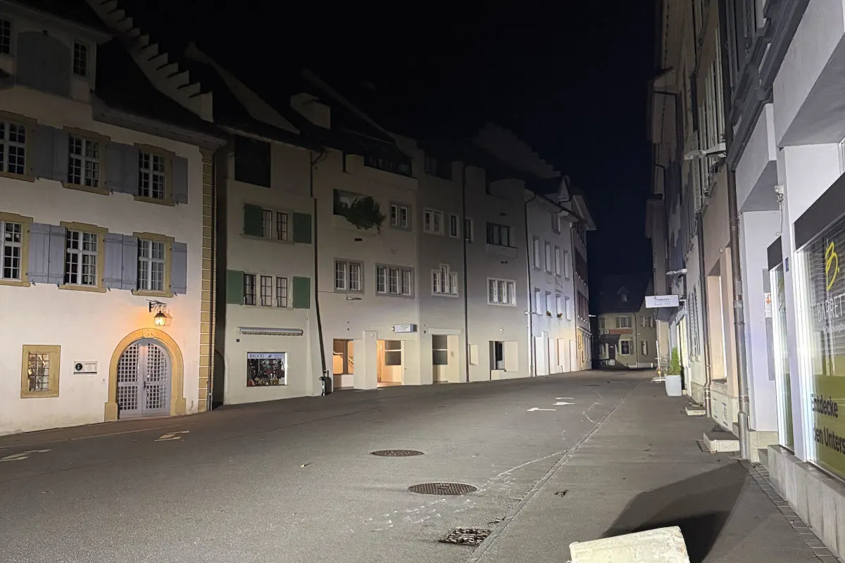 Das Foto zeigt eine leere Gasse in einer Altstadt bei Nacht. Die Gebäude sind ansprechend beleuchtet, und es sind keine Menschen zu sehen.