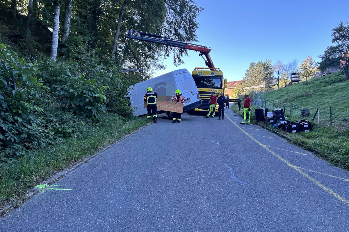 Ein umgekippter Transporter wird von einem Kran auf einer Landstraße angehoben. Einsatzkräfte sind vor Ort.