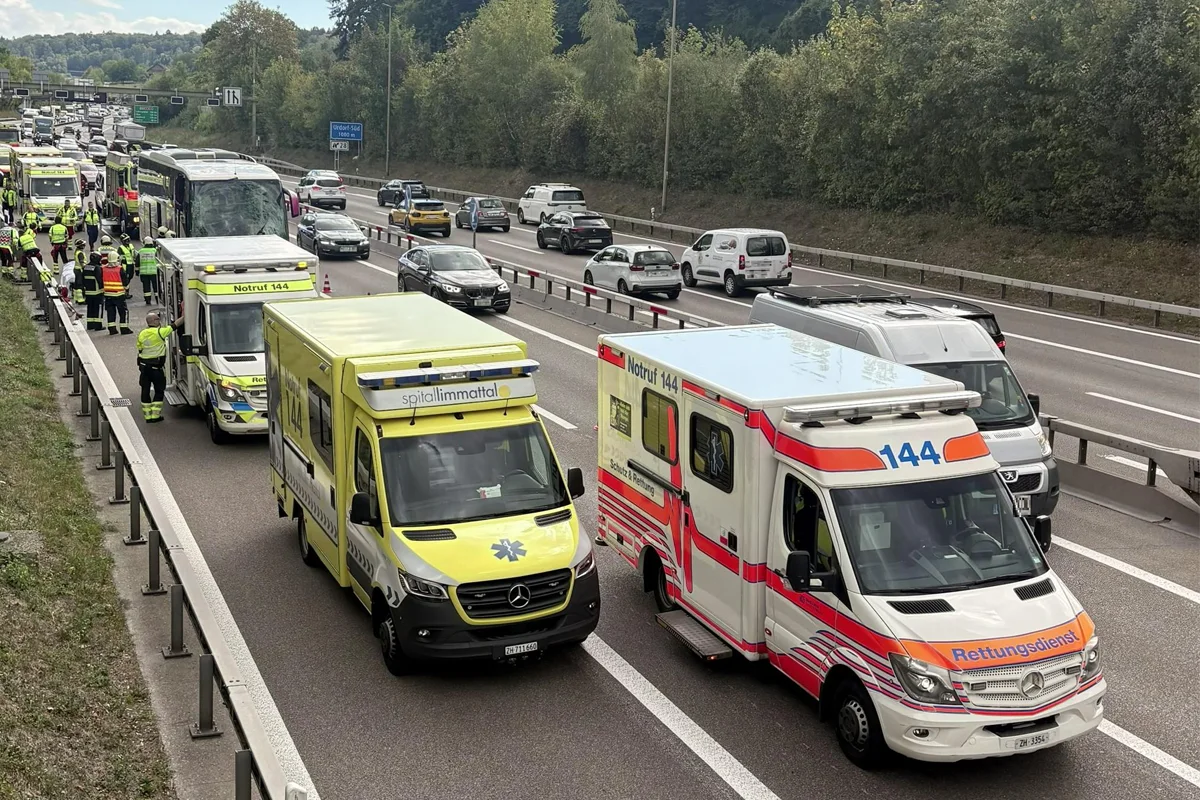 Mehrere Rettungsfahrzeuge stehen auf einer Autobahn, umgeben von Einsatzkräften, die offenbar bei einem Unfall helfen.