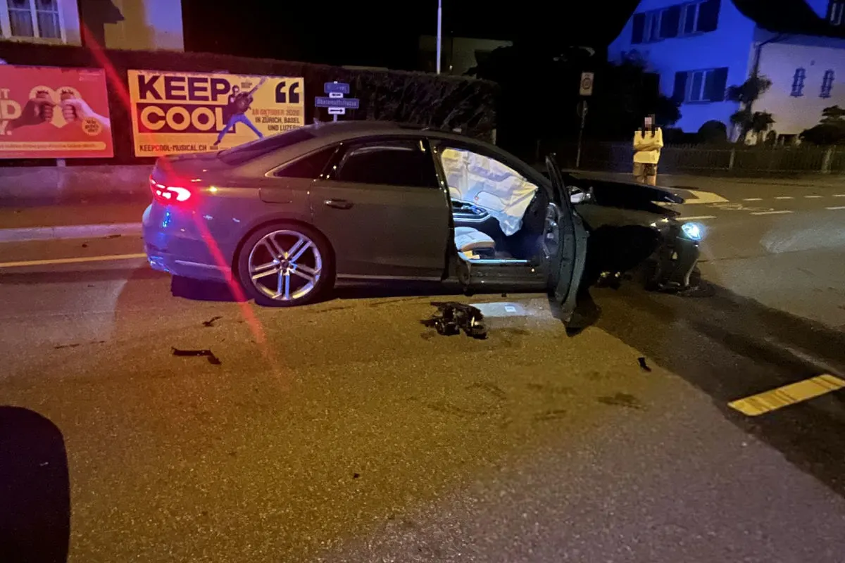 Ein Auto steht bei Nacht auf einer Straße mit geöffneten Türen; der Unfall hat offensichtlich Schäden verursacht.
