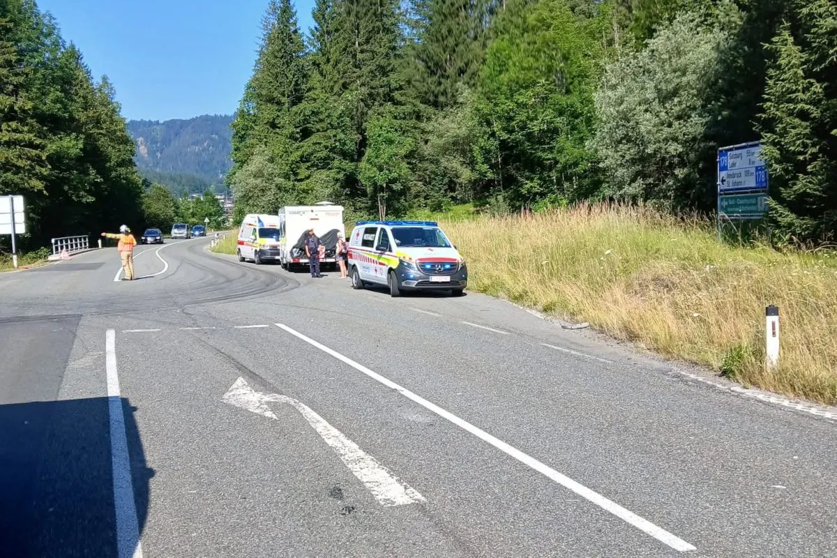 Mehrere Einsatzfahrzeuge parken auf einer Landstraße, daneben stehen Menschen, als Teil eines Einsatzes im Grünen.