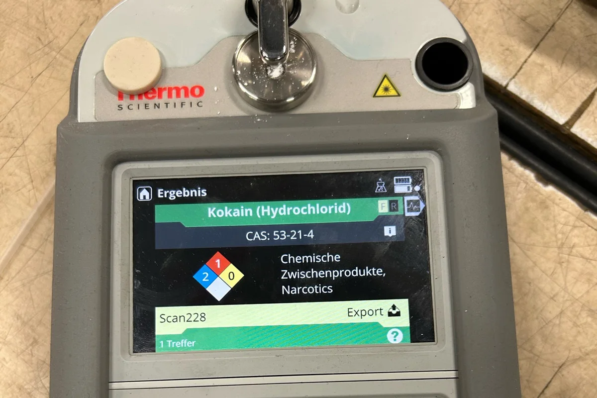Ein Analysegerät zeigt das Ergebnis der Substanzanalyse für Kokain (Hydrochlorid) auf einem digitalen Display. Oben links ist das Firmenlogo 'Thermo Scientific' zu sehen.